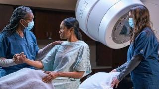 Patient about to undergo radiation imaging, holding nurse's hand