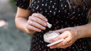 Woman opening pack of nicotine patches and taking one