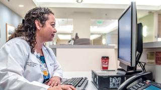 Nurse looking at computer screen 1024x475