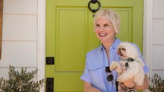 Donna McNutt holding her dog in front of a door