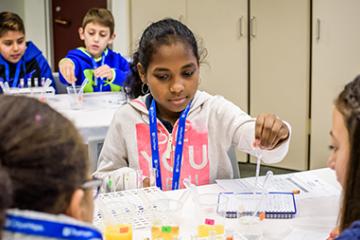 young girl using lab utensils 