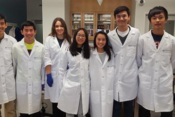 group of high school students in lab coats
