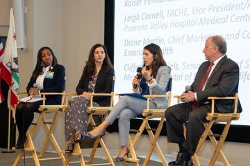 a panel of experts speaking on stage